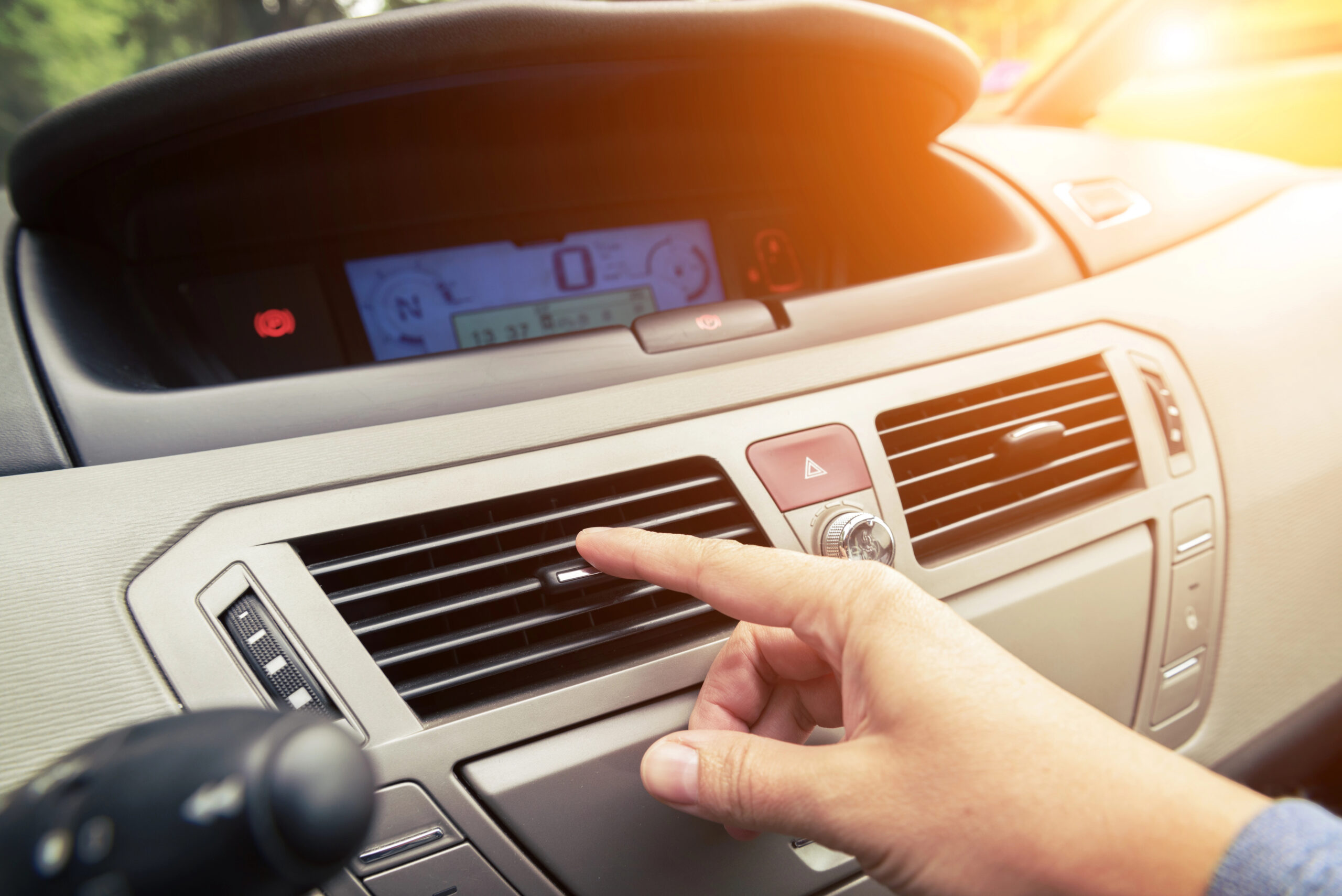 Driver's hand reaching for AC vent.