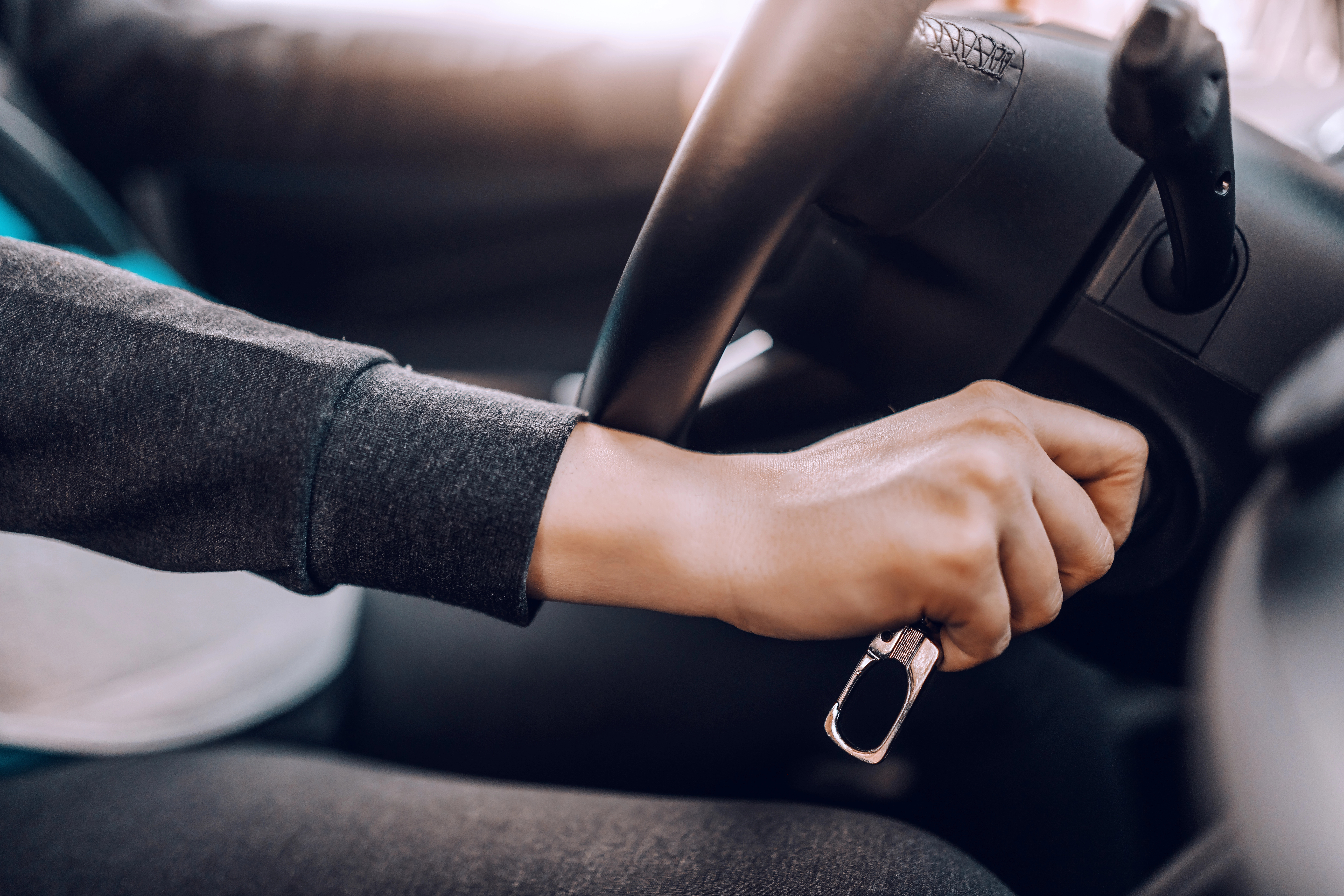 Close up of woman starting car with key.