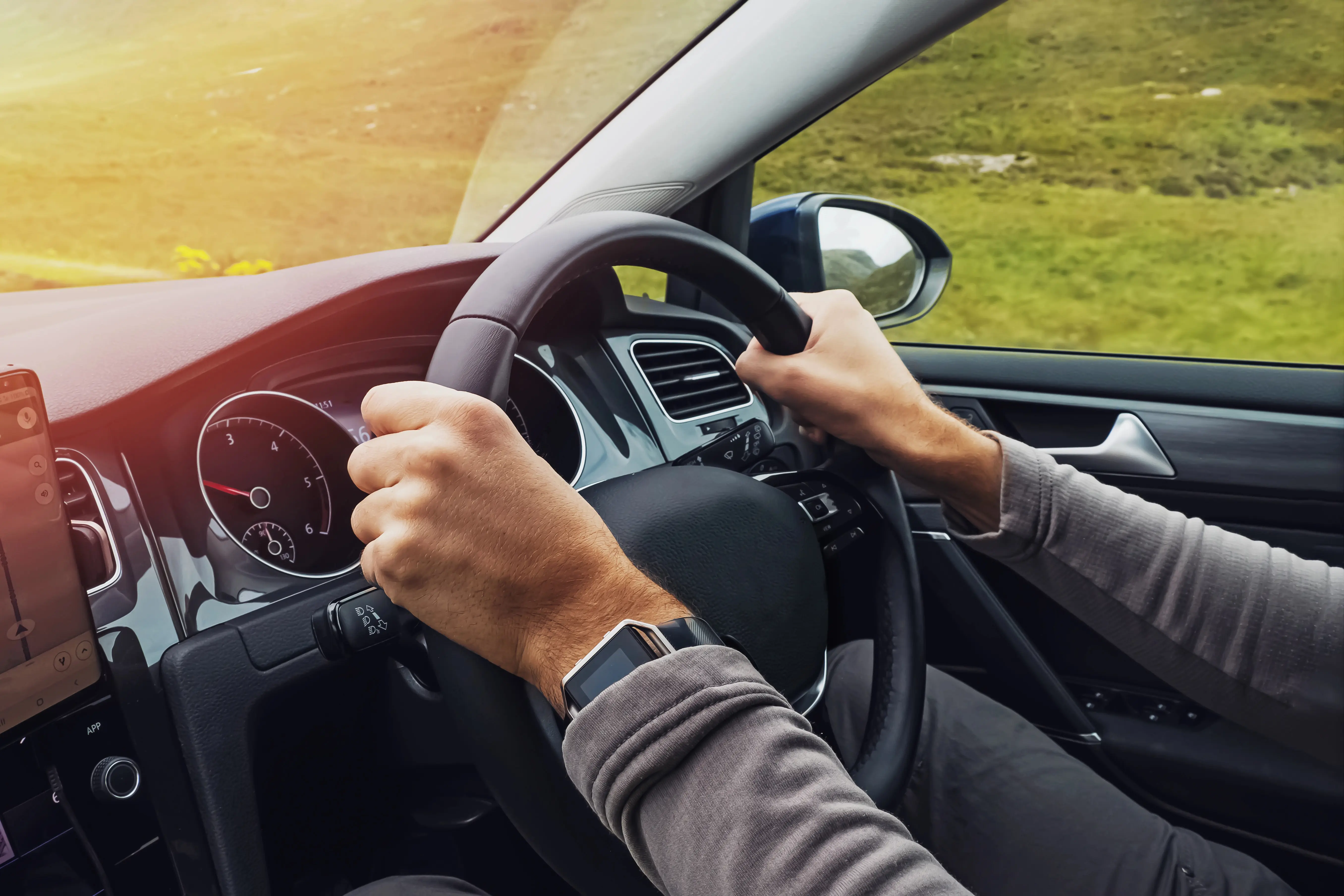 Persons hands driving right hand drive vehicle