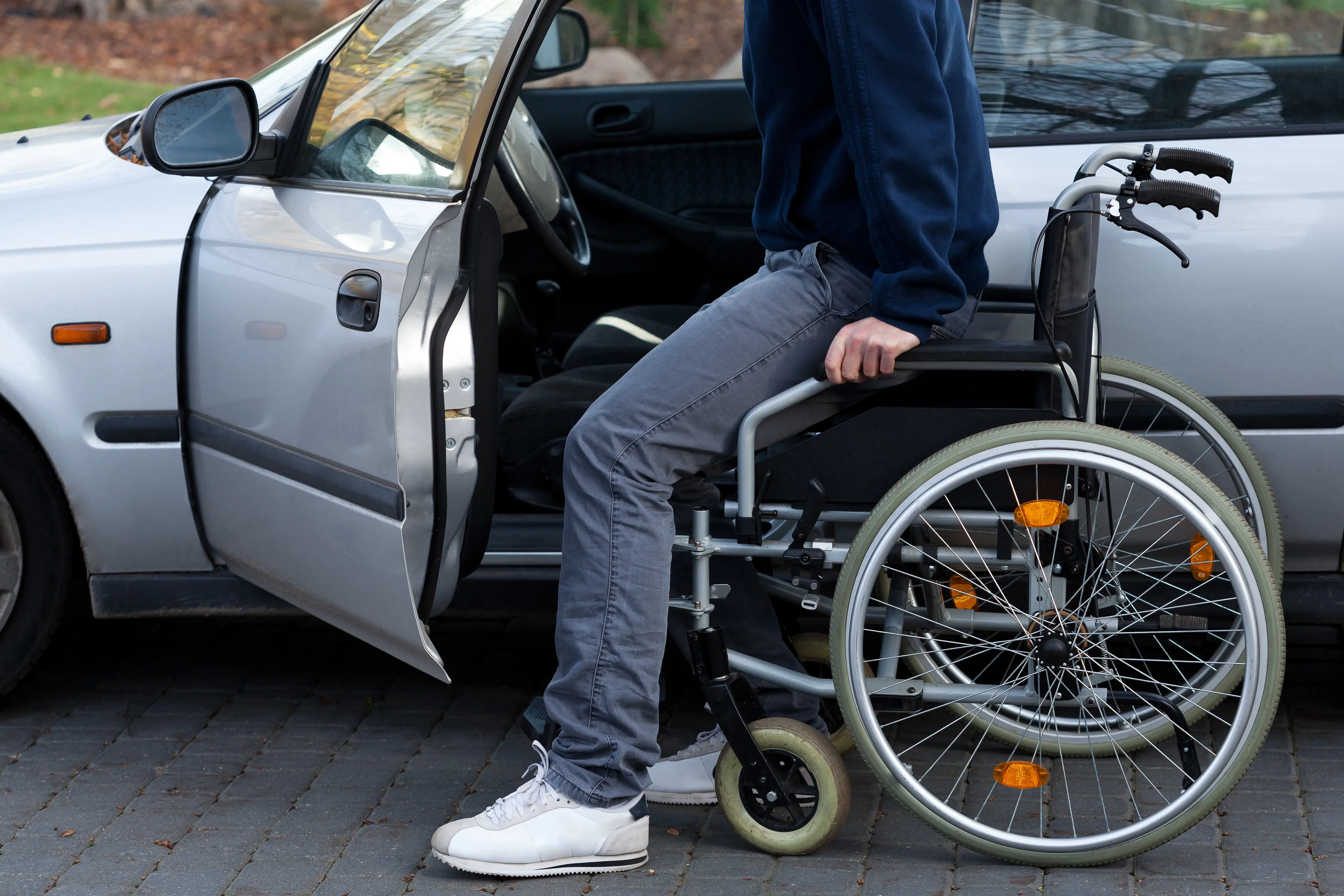 Disabled driver getting into car from wheelchair