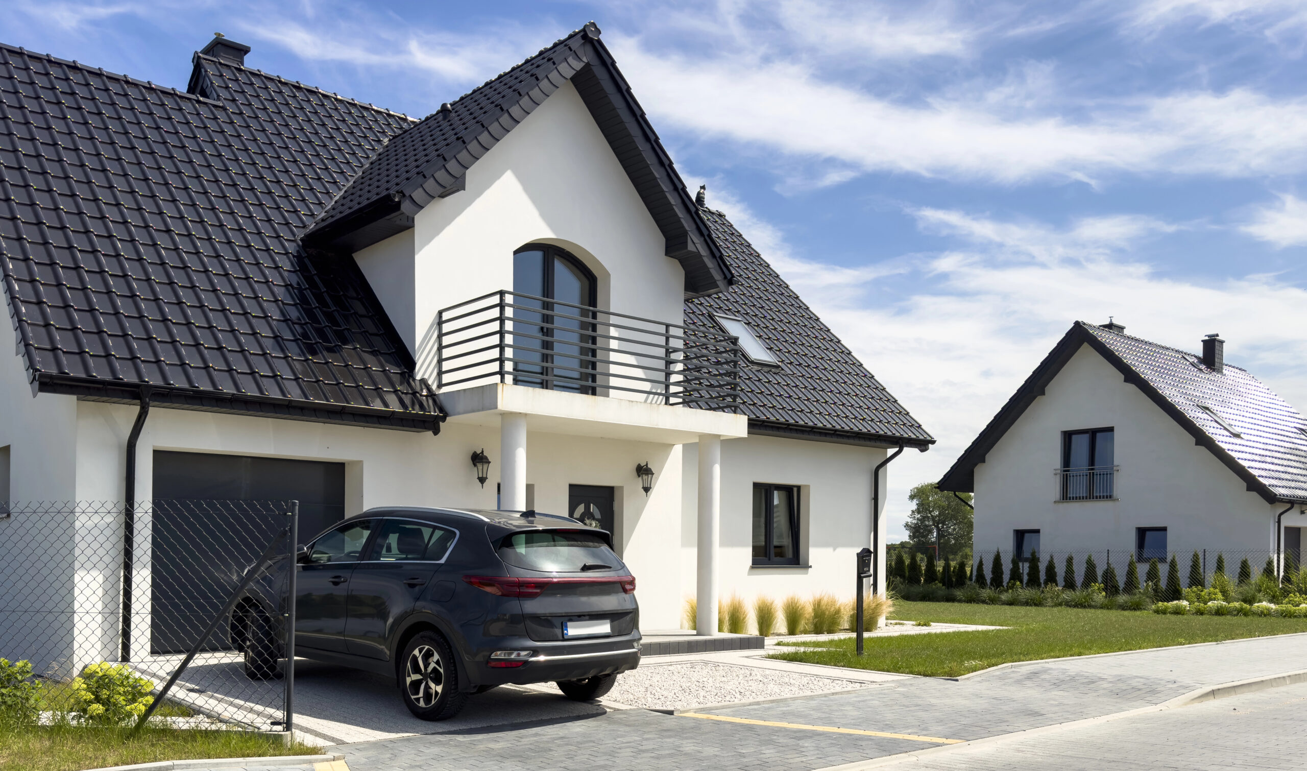 Exterior of a modern single family home with SUV in the driveway.
