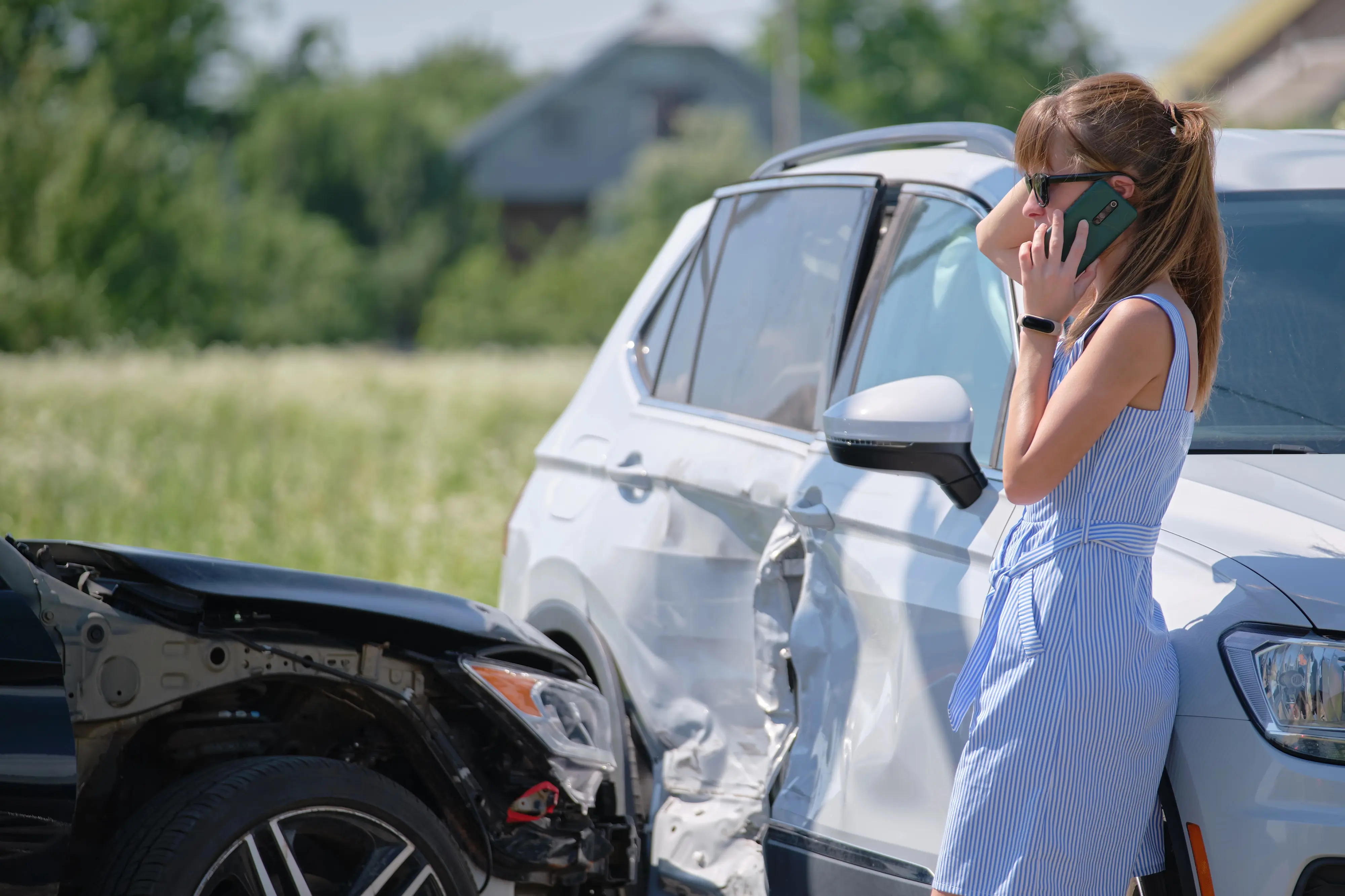 Women standing beside car accident on the phone stressed