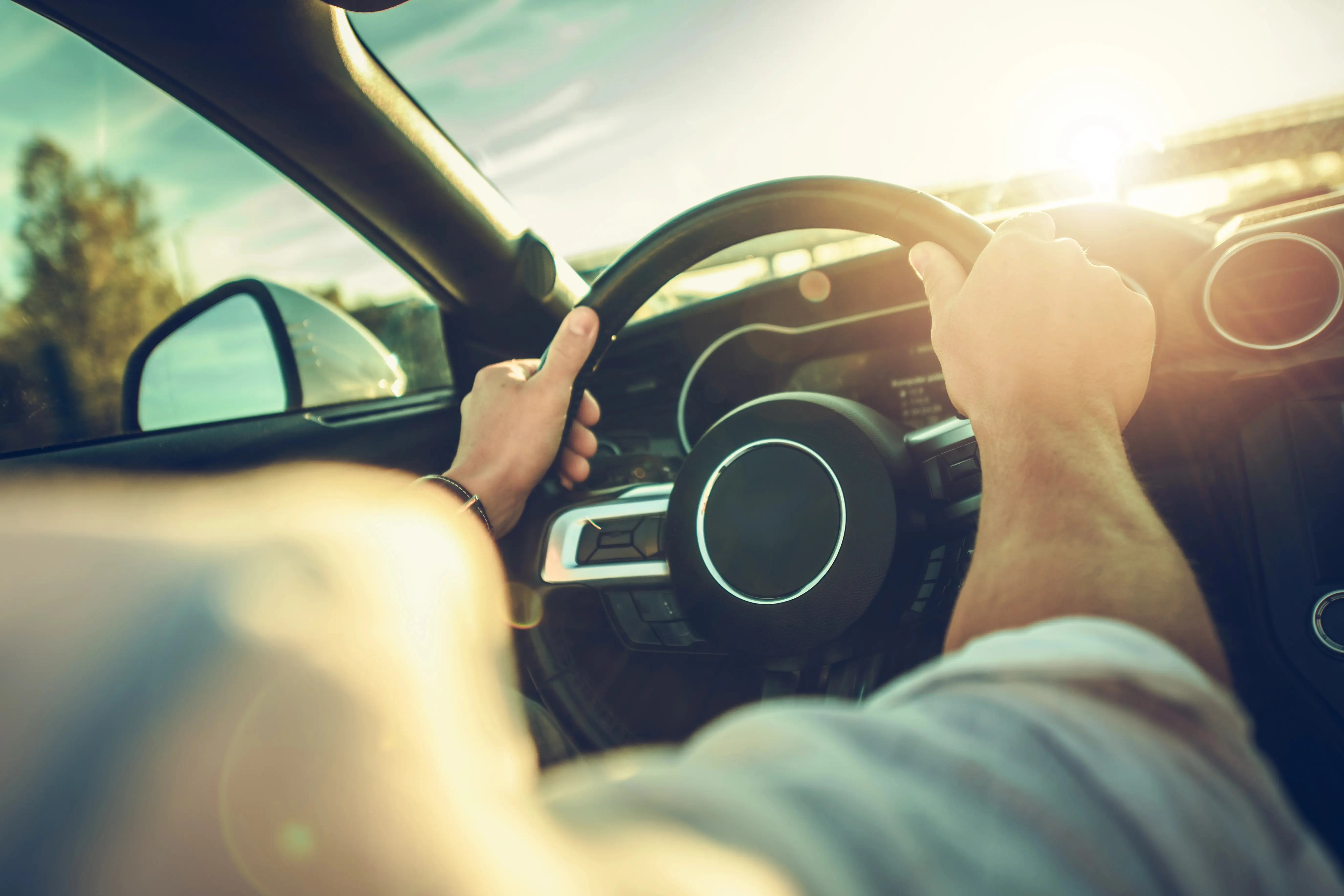 Man behind steering wheel in the sun
