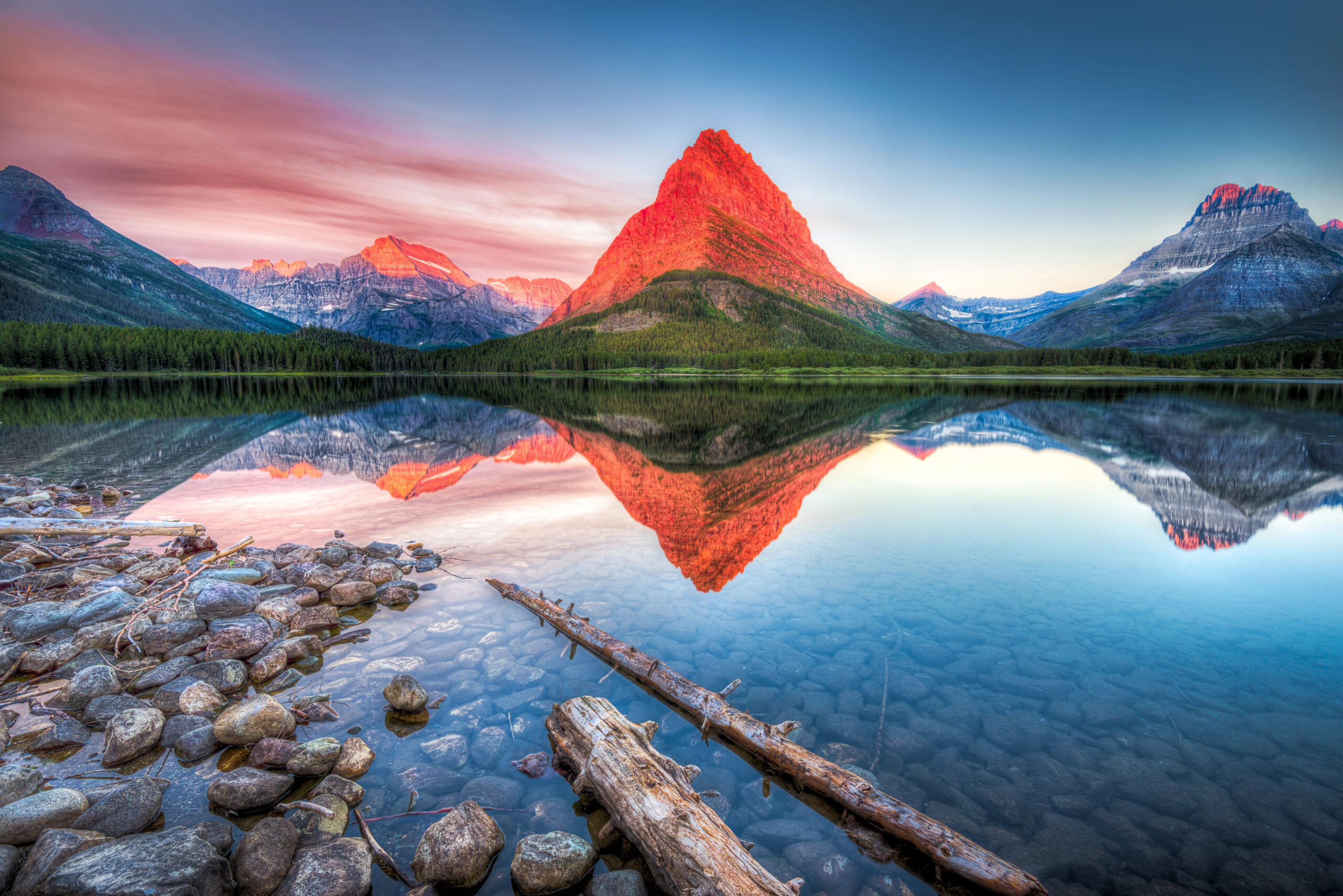 Stunning reflections on Swiftcurrent Lake in northern Montana at sunrise.